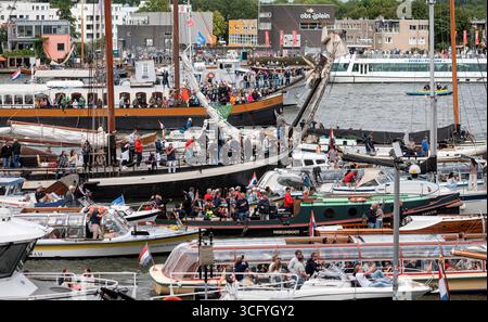 Amsterdam Niederlande 23. August 2025 Tausende säumen die Küste von Het ij und den Hafen von Amsterdam für das fünfjährliche Sail Tall Ships Event. Eine große Anzahl von Besucherbooten lässt den Eindruck entstehen, als ob es möglich wäre, von einem Boot zum anderen zu springen, um nach Amsterdam Noord zu überqueren. HAVEN, Sail25, People, Niederländisch, Nederland, Holland, Besucher, drukte, Stockfoto