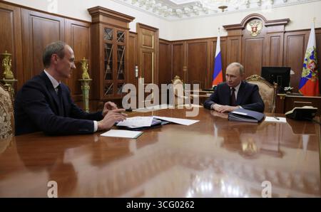 Moskau, Russland. August 2025. Der russische Präsident Wladimir Putin, rechts, hört dem stellvertretenden Ministerpräsidenten Dmitri Grigorenko zu, der seinen Bericht während eines persönlichen Treffens im Kreml am 25. August 2025 in Moskau, Russland, vorlegt. Quelle: Vyacheslav Prokofyev/Kreml Pool/Alamy Live News Stockfoto