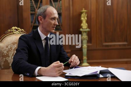 Moskau, Russland. August 2025. Der stellvertretende russische Ministerpräsident Dmitri Grigorenko, Chef des Regierungsstabs, übergibt Präsident Wladimir Putin seinen Bericht während eines persönlichen Treffens im Kreml am 25. August 2025 in Moskau. Quelle: Vyacheslav Prokofyev/Kreml Pool/Alamy Live News Stockfoto