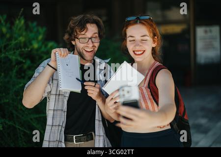 Zwei fröhliche Studenten machen ein Selfie im Freien an einem sonnigen Tag Stockfoto