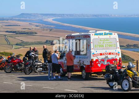 Abbotsbury, Dorset, Großbritannien. August 2025. Wetter in Großbritannien. Urlauber halten an, um in einem Lay-by-Van an der Spitze der B3157 Coast Road in Abbotsbury in Dorset ein Eis zu kaufen, von dem aus Sie an einem heißen, sonnigen Feiertag im August einen Panoramablick auf die Flotte und die St. Catherine's Chapel haben. Foto: Graham Hunt/Alamy Live News Stockfoto