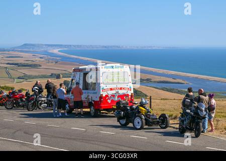 Abbotsbury, Dorset, Großbritannien. August 2025. Wetter in Großbritannien. Urlauber halten an, um in einem Lay-by-Van an der Spitze der B3157 Coast Road in Abbotsbury in Dorset ein Eis zu kaufen, von dem aus Sie an einem heißen, sonnigen Feiertag im August einen Panoramablick auf die Flotte und die St. Catherine's Chapel haben. Foto: Graham Hunt/Alamy Live News Stockfoto