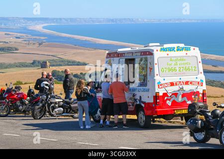 Abbotsbury, Dorset, Großbritannien. August 2025. Wetter in Großbritannien. Urlauber halten an, um in einem Lay-by-Van an der Spitze der B3157 Coast Road in Abbotsbury in Dorset ein Eis zu kaufen, von dem aus Sie an einem heißen, sonnigen Feiertag im August einen Panoramablick auf die Flotte und die St. Catherine's Chapel haben. Foto: Graham Hunt/Alamy Live News Stockfoto