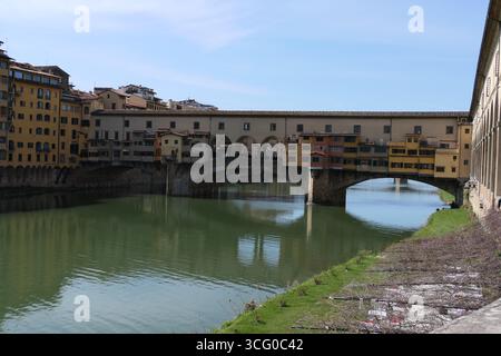 Die Ponte Vecchio, die berühmte mittelalterliche Brücke von Florenz über den Fluss Arno, gesäumt von bunten Geschäften und reich an Geschichte und Charme. Stockfoto
