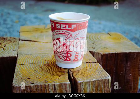Zwei Pappbecher Kaffee auf einem Holzständer am DOT. cafe Stockfoto
