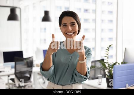 Porträt einer selbstbewussten Frau, die lächelt und zwei Daumen hochlegt Stockfoto