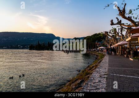 Promenade am See und Abendessen im Freien bei Sonnenuntergang am Lago di Garda, Italien Stockfoto