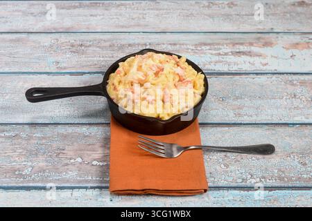 Eine köstliche Hilfe aus Hummer-regenmantel und einer Mini-Gusseisenpfanne auf einer rustikalen Tischplatte. Stockfoto
