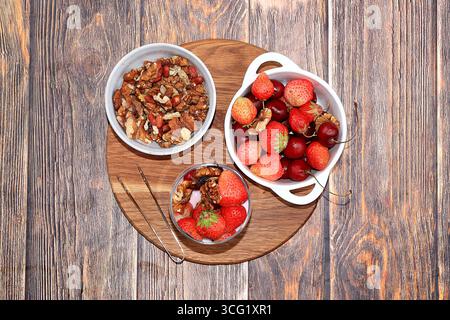 Nützliches Frühstück, Essen für Kinder, Erdbeerjoghurt, Smoothies und Müsli auf einem hellen Tisch. Das Konzept der gesunden und natürlichen Ernährung. Selektiv fo Stockfoto