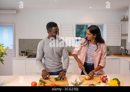 Diverse Paare zu Hause Küchentheke hacken frisches Gemüse auf hölzernen Schneidebrettern Stockfoto