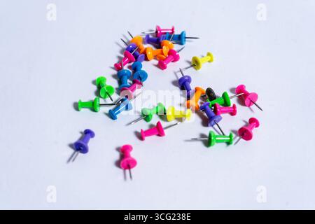 Lebendige Push-Pins schaffen ein farbenfrohes Display auf einem sauberen weißen Hintergrund, perfekt für Bürobedarf, Schulprojekte oder kreative Endea Stockfoto