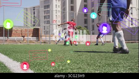 Dribbling man in roter Uniform, der Fußball auf einem städtischen Rasenfeld kontrolliert, mit Analyseüberlagerungen Stockfoto