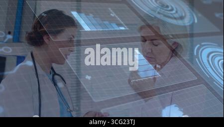 Analyse zweier Ärztinnen, die an holographischen Karten in der Klinik Gesten mit Stethoskop und Stift machen Stockfoto