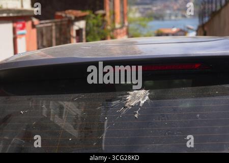 Vogelkot auf einem geparkten Auto in einer engen Straße Stockfoto
