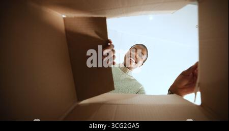 Schwarze Frau, offene Box und Lächeln mit POV zu Hause, Low Angle oder E-Commerce für Produkt, Bestellung oder Lieferung. Person, aufgeregt und zufrieden mit Pappe Stockfoto