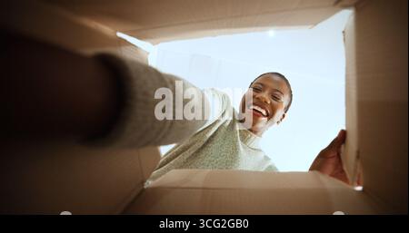 Schwarze Frau, offene Box und zufrieden mit POV zu Hause, Low Angle oder E-Commerce für Produkt, Bestellung oder Lieferung. Person, aufgeregt und lächelt mit Pappe Stockfoto