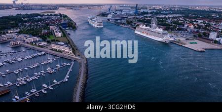 Rostock, Deutschland. August 2025. Das Kreuzfahrtschiff 'AIDAmar' passiert am Morgen die Schiffe 'Viking Sky' (rechts) und 'Rotterdam' (hinten) auf dem Meereskanal. Die Segelboote liegen morgens im Jachthafen des Hotelkomplexes hohe Düne. Insgesamt drei Kreuzfahrtschiffe mit insgesamt 12.000 Gästen legen während des zweiten Triple-Call bis zum Abend am Kreuzfahrtterminal in Warnemünde an. Quelle: Jens Büttner/dpa/Alamy Live News Stockfoto