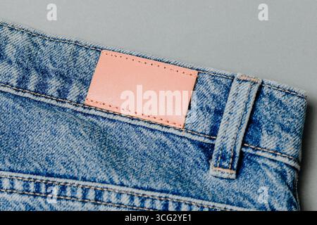 Leeres Jeans-Etikett aus Leder auf eine blaue Jeans aufgenäht. modell für Design Stockfoto