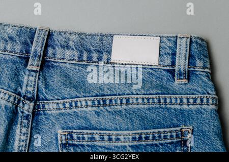 Leeres Jeans-Etikett aus Leder auf eine blaue Jeans aufgenäht. modell für Design Stockfoto