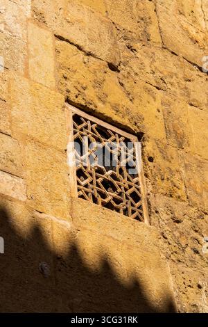Raffinierter Fenstergrill aus geometrischem Stein im historischen Cordoba, Spanien, mit maurisch-islamischem Architekturerbe und andalusischer Handwerkskunst Stockfoto