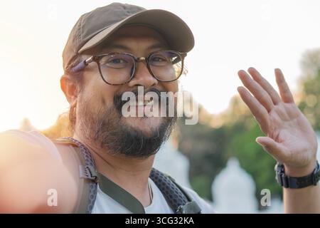 Schöner erwachsener Mann, der draußen Selfie mit Smartphone macht. Close-up-Porträt-Konzept. Stockfoto