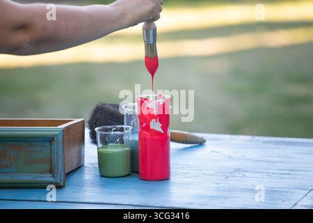 Holzmöbel mit Kreidemalerei aus menschlicher Hand. Alte Holzmöbel werden mit brandneuer, farbenfroher Kreidefarbe erneuert. Die Innendekoration wird neu gestaltet Stockfoto