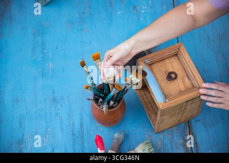 Holzmöbel mit Kreidemalerei aus menschlicher Hand. Alte Holzmöbel werden mit brandneuer, farbenfroher Kreidefarbe erneuert. Die Innendekoration wird neu gestaltet Stockfoto