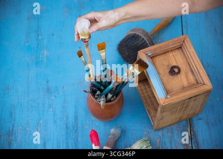 Holzmöbel mit Kreidemalerei aus menschlicher Hand. Alte Holzmöbel werden mit brandneuer, farbenfroher Kreidefarbe erneuert. Die Innendekoration wird neu gestaltet Stockfoto