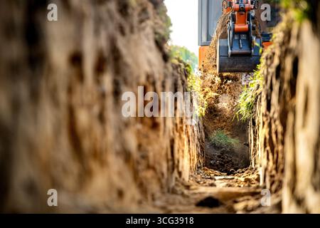 Minibagger zum Heben von Erde aus dem Graben auf der Baustelle Stockfoto