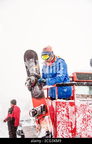 Sheregesh, Russland, 4. Februar 2017, Snowboarder, der im verschneiten Bergskigebiet aus der Schneekatze steigt Stockfoto