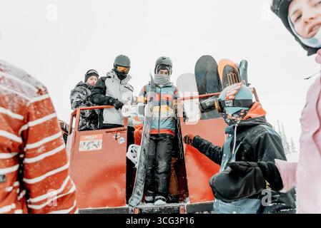 Sheregesh, Russland, 4. Januar 2021, Snowboarder, der im verschneiten Bergskigebiet aus der Schneekatze steigt Stockfoto