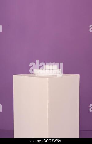 Zeitgenössischer, abstrakter Sockel mit geometrischen Formen in weiß vor einem leuchtenden lila Hintergrund Stockfoto