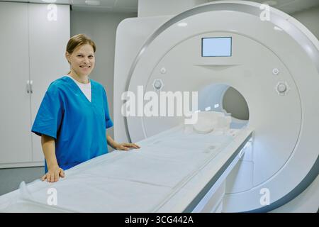 Kaukasische junge Erwachsene Frau lächelt beim Betrieb des MRT-Scanners im Krankenhaus Stockfoto