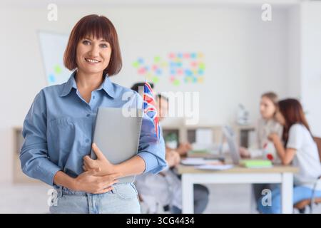 Englischlehrerin mit britischer Flagge im Schulbüro Stockfoto