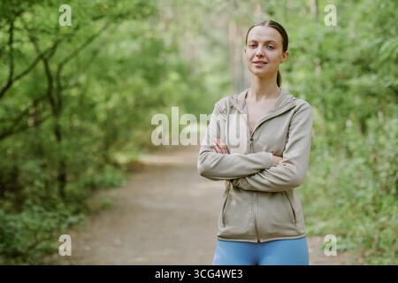 Porträt einer jungen Erwachsenen kaukasischen Frau, die selbstbewusst draußen steht Stockfoto