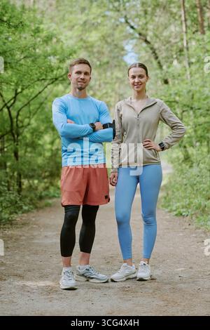 Kaukasischer junger Mann und Frau stehen zusammen im Wald Stockfoto