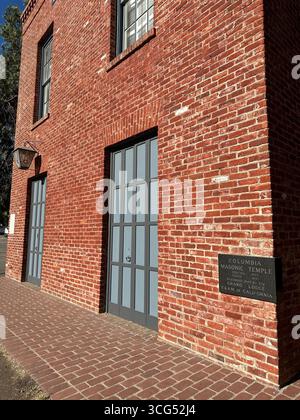 Eine Laterne mit dem Freimaurerplatz und dem Kompass-Symbol hängt außen an einem historischen Gebäude aus roten Backsteinen. Stockfoto