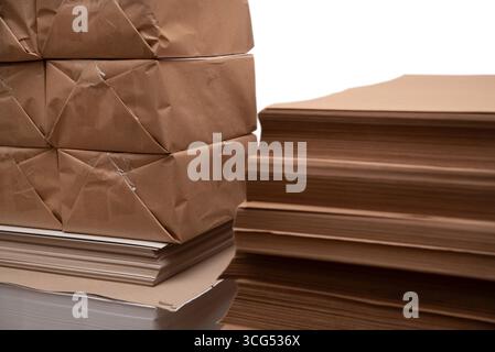 Braune Papierbögen und -Pakete stapelweise, in der Druckindustrie, Produktpakete und Kraftpapier. Betonung der Verwendung natürlicher Materialien und s Stockfoto