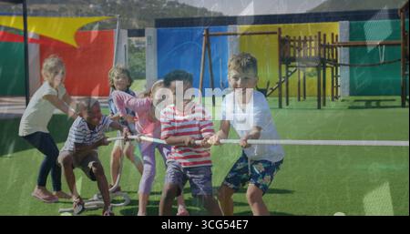 Eine Gruppe von sechs Kindern, die auf einem Kunstrasenfeld Tauziehen, mit dickem weißem Seil Stockfoto