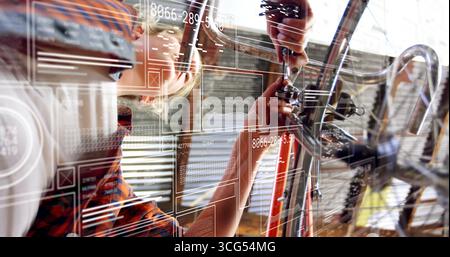 Fahrradmechanikerin mit Schürze, die den Lenkerschaft in der Reparaturwerkstatt verstellt, mit AR-Überzügen Stockfoto