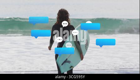Stehende Surferin mit hellblauem Surfbrett an der Küste, mit Taucheranzug und Chat-Blasen Stockfoto