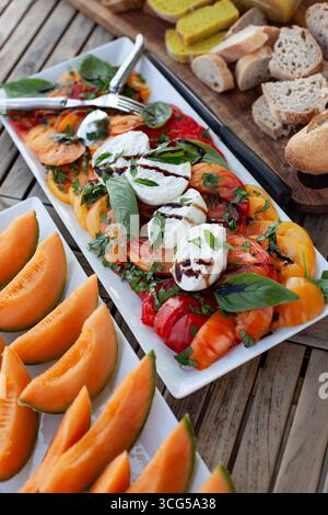 Tomatensalat und Melone auf einem Tisch Stockfoto