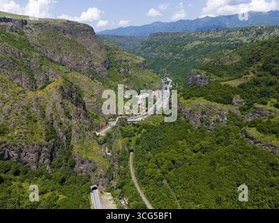 Blick auf das Tal mit Straßen, Tunneln und Häusern in grüner Berglandschaft, aus der Vogelperspektive, Landschaft in der Nähe von Dzoraget, Fluss Pambak vor dem Tunnel, Stockfoto
