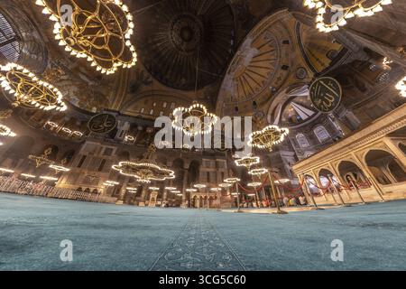 Weitwinkelblick auf das Innere der hagia sophia in istanbul, türkei, mit seiner herrlichen Kuppel, komplizierten Mosaiken und großen Kronleuchtern Stockfoto