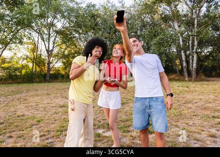 Eine Gruppe von Freunden macht ein Selfie im Park und genießt einen sonnigen Tag Stockfoto