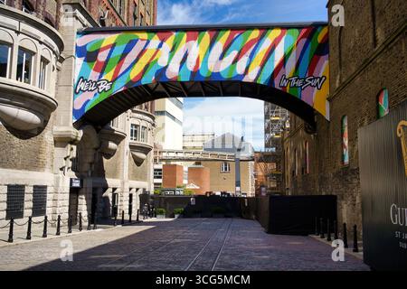 Eine lebendige Straßenszene in Dublin, Irland, mit einem bunten Fußweg mit künstlerischen Graffitis und einem bogenförmigen Design. Stockfoto