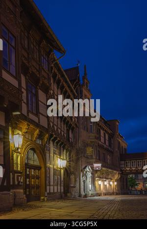 Traditionelle Fachwerkhäuser in der Braunschweiger Altstadt, die während der abendlichen blauen Stunde wunderschön von Laternen beleuchtet werden. Ein historisches und romantisches Stadtbild Stockfoto
