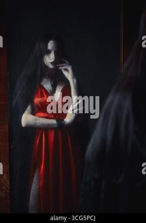 Horrorszene: Verschwommenes Spiegelbild des Geistermädchens im alten schmutzigen Spiegel. Porträt der Vampirfrau Stockfoto
