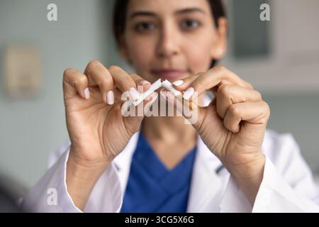 Junge Ärztin bricht Zigaretten aus der Nähe Stockfoto