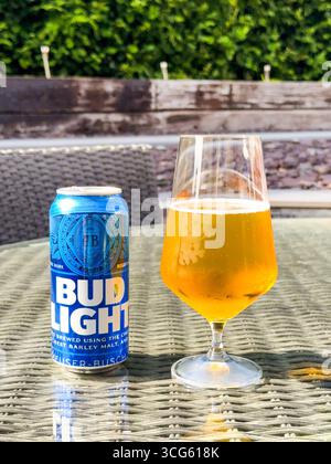 Cardiff, Wales, Großbritannien - 19. Juni 2025: Offene Dose und Glas voll Bud Light Lagerbier auf einem Tisch im Garten eines Hauses. Stockfoto